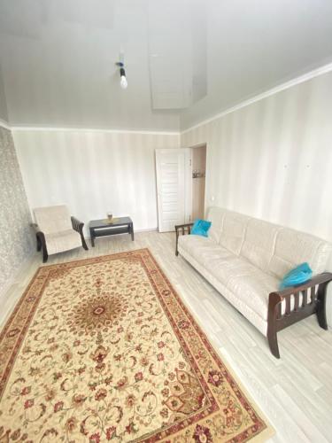 阿克托比2-х комнатная квартира напротив аквапарка的客厅配有白色沙发和地毯。