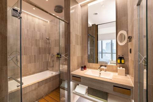 香港Nina Hotel Kowloon East的一间带水槽、浴缸和淋浴的浴室