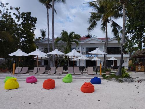 邦劳Villa Umi Panglao Resort的海滩上一群五颜六色的椅子和遮阳伞