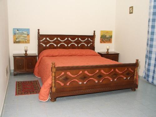 米斯泰尔比安科Agriturismo Ruvitello的一间卧室配有一张带橙色床罩的床
