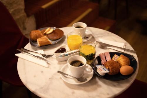 巴黎帕特里克·哈亚特剧院酒店的一张带早餐食品和饮料的白色桌子