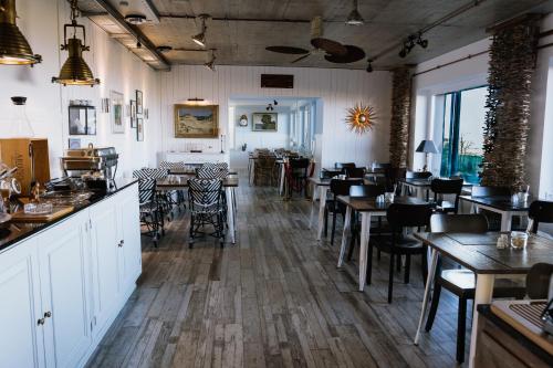 库克斯港Beachhotel Cuxhaven的一间带桌椅的餐厅和一间酒吧