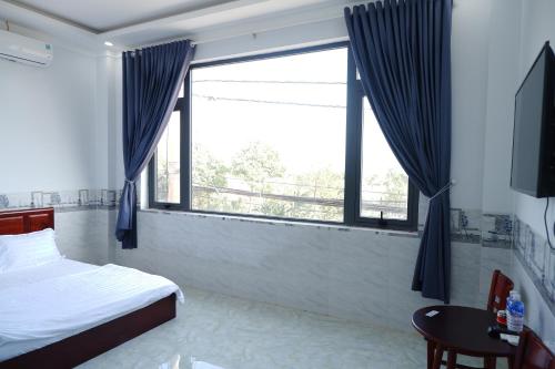 邦美蜀Thinh Khang Guesthouse的一间卧室设有一张床和一个大窗户