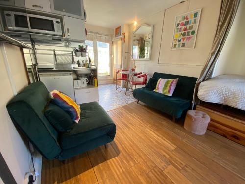 布莱顿霍夫Little Western Spa Brighton Beach Apartments的客厅配有绿色沙发和床。