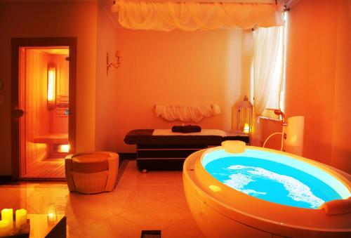 热莱胡夫热莱胡夫宫温泉疗养酒店的一间带浴缸的浴室位于客房中间
