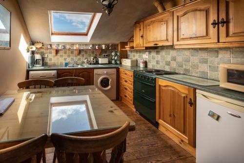 杜林Atlantic View Cottages的厨房配有木制橱柜和桌椅
