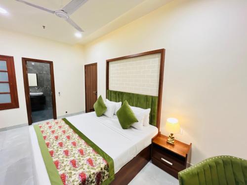 阿姆利则Hotel The Orchid Tree Amritsar - walking from Golden Temple的一间卧室配有一张大床和一把椅子