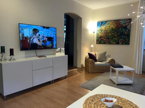 梅森Stadthaus Rosengasse的客厅配有白色橱柜上的平面电视