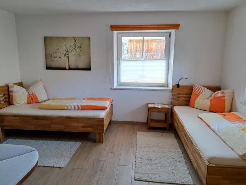 绍滕斯Apart4You Ötztal的客房设有两张床和窗户。