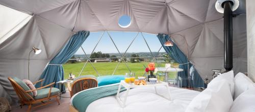 LochwinnochThe Dome at Mid Auchengowan的帐篷配有一张床和一张桌子