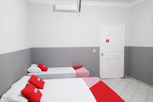 圣保罗OYO Hotel Brás的配有红色和白色床单的客房内的两张床