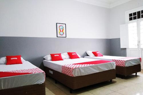 圣保罗OYO Hotel Brás的宿舍间内的两张床,配有红色枕头