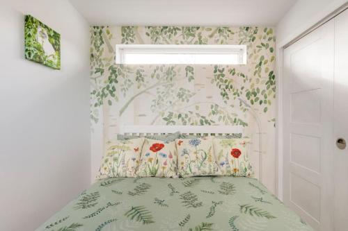 TarvesCosy and modern 1 bedroom garden house - very dog friendly!的卧室配有一张墙上鲜花的床