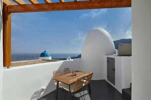 Éxo GoniáAecon Suites的阳台上配有小桌子和椅子,享有海景