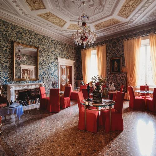 摩德纳萨洛托阿尔阿提酒店的一间带椅子和桌子的房间以及壁炉