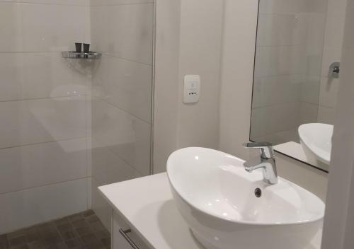 比勒陀利亚Regency Apartment的白色的浴室设有水槽和淋浴。