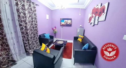 杜阿拉Residence Sighaka - Gold Apartment - WiFi, Gardien, Parking的一间设有两把椅子和电视的等候室