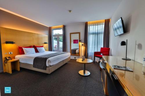 列日酷洛内列日酒店的酒店客房,配有床和电视