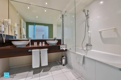 列日酷洛内列日酒店的一间带两个盥洗盆和淋浴的浴室