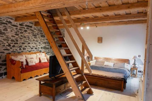 西克斯特Gîte ferme en permaculture avec ses animaux的阁楼卧室设有一张床和一个楼梯