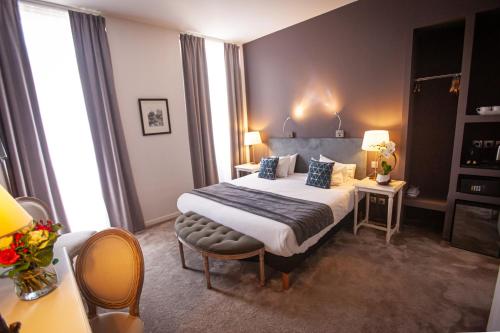波尔多波尔多中心丘吉尔酒店的酒店客房带一张床、一张桌子和椅子