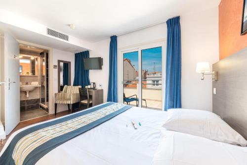 戛纳赫哲酒店的一间卧室配有一张床,享有一间浴室的景色