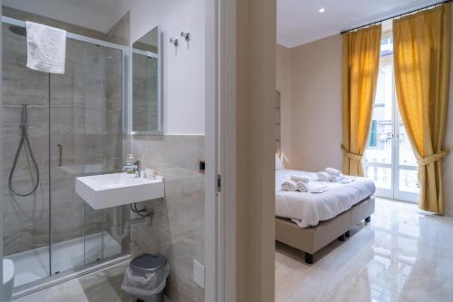 圣雷莫Correnti Boutique Hotel Gold的配有床、淋浴和盥洗盆的浴室