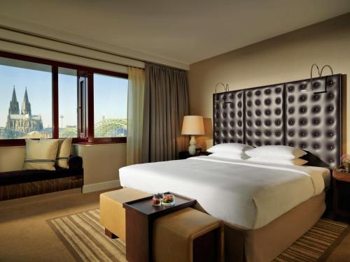 科隆科隆凯悦酒店的一间酒店客房,设有一张大床和一个大窗户