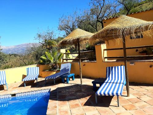 比纽埃拉Los Montes Traditional Casa with private pool的三把蓝白椅子和一个游泳池