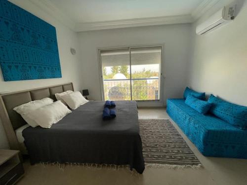 哈马马特Villa des Oliviers Hammamet B&B的一间卧室配有一张床和一张蓝色的沙发
