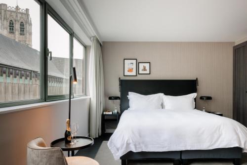 布鲁塞尔Pillows City Hotel Brussels Centre的配有一张床和一把椅子的酒店客房