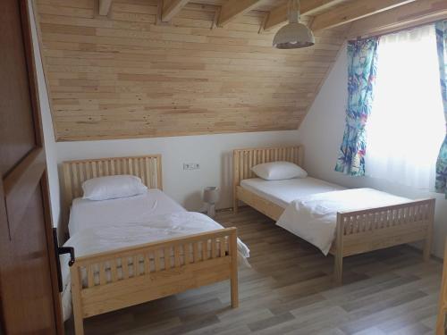 契拉勒Bellerofon villa的配有木墙和木地板的客房中的两张床