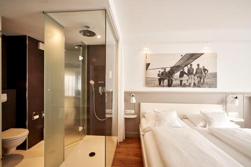 Sankt MichaelisdonnDer Kleine Hans的一间卧室设有一张床和一个玻璃淋浴间