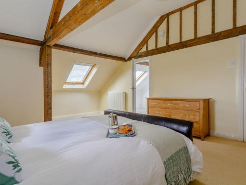 北伍顿Mulberry Cottage的一间卧室配有一张床,上面放着一个食物托盘
