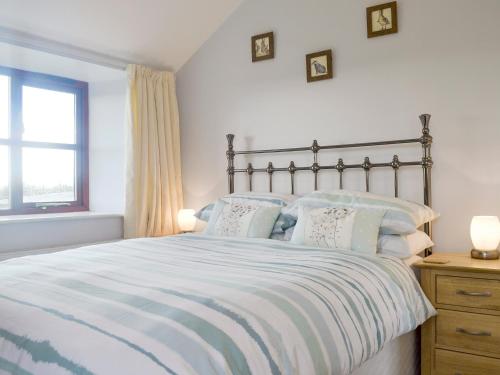 北伍顿卡瑞美度假屋的卧室配有带枕头的大床和窗户。