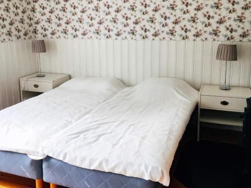 MalmköpingHoliday home ESKILSTUNA V的卧室配有白色的床和2个床头柜