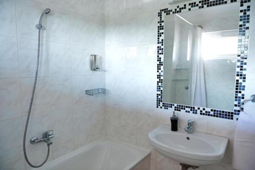 洛约什米热Liza Aqua & Conference Hotel的带浴缸、水槽和淋浴的浴室