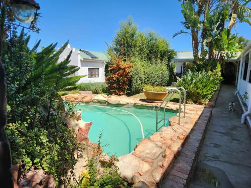 奥茨胡恩Best Little Guesthouse -Beit Shalom的一座小游泳池,位于一个拥有岩石的庭院内