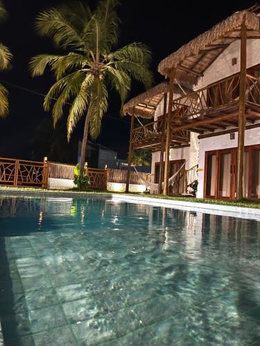 伊卡莱Casa di Maria flats的棕榈树屋前的游泳池