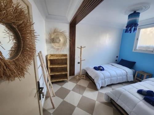 阿加迪尔Green Surf House的卧室配有两张床,墙上有一个十字架
