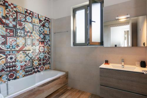 马鲁拉斯Villa Elia的带浴缸、水槽和镜子的浴室