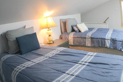 匹兹堡3 BR Southside Pad - Sleeps 8 - Amazing Location的一间卧室设有两张床和一张桌子上的台灯。