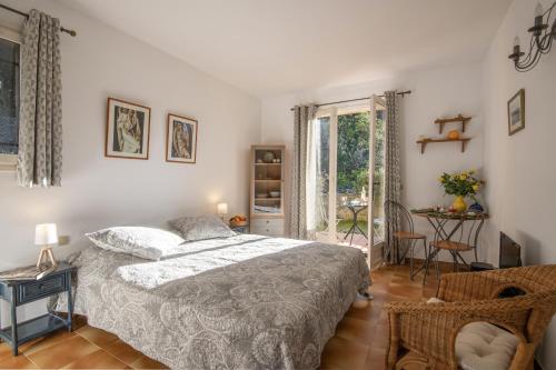 圣保罗-德旺斯Le Mas des Gardettes的卧室配有床、椅子和窗户。