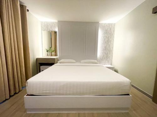 罗勇卡普迪恩酒店的卧室配有白色的床