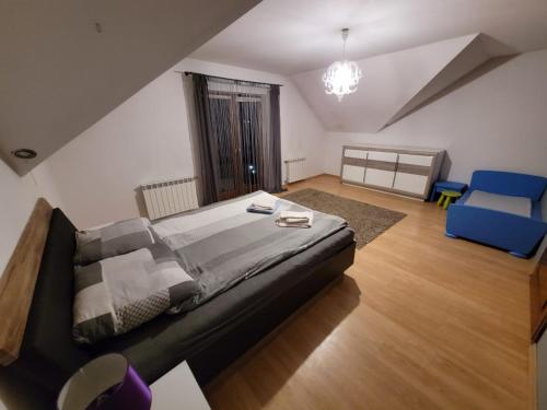 拉布卡Cztery Pory Roku的一间卧室配有一张大床和一张蓝色椅子