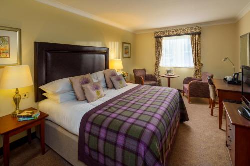 普雷斯顿麦克唐纳德提科尔鳟鱼度假酒店的酒店客房设有一张大床和一张书桌。