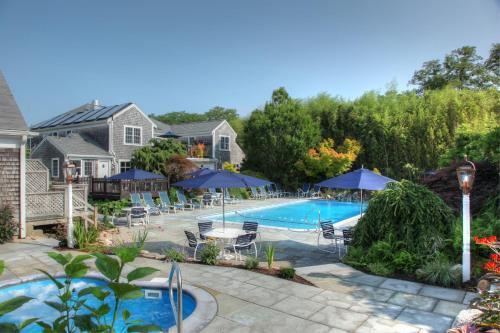 查塔姆宜人海湾村度假酒店的一个带庭院家具和遮阳伞的游泳池