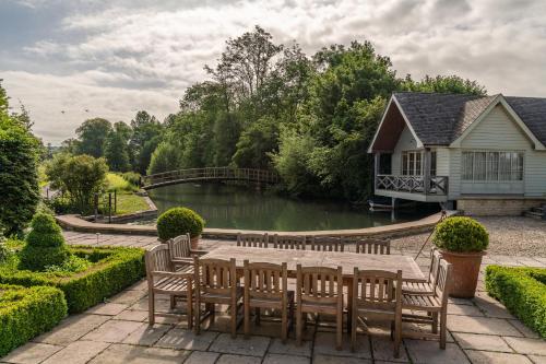 AlderleyGrindstone Mill的池塘旁的木桌和椅子