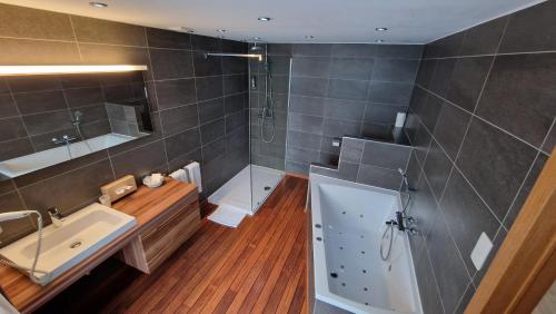 勒穆尚皇家伯恩霍姆餐厅酒店的带浴缸、水槽和淋浴的浴室