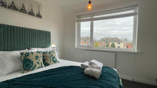 杜伦Fully Serviced Three Bed House in Durham的一间卧室配有一张带绿色床头板的床和窗户